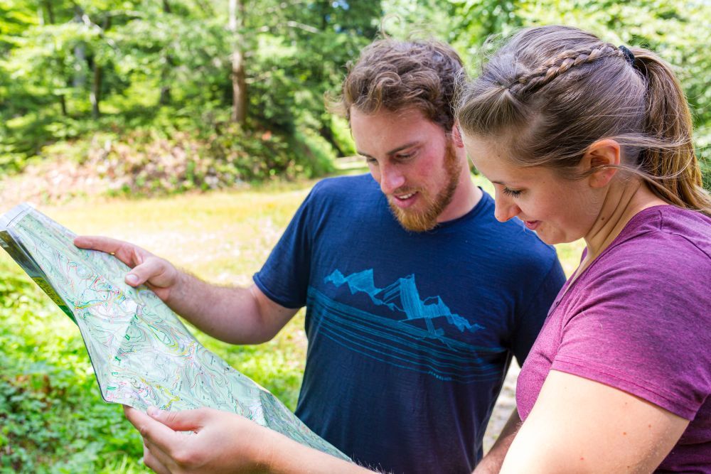 Ein Mann und eine Frau schauen in eine Wanderkarte.