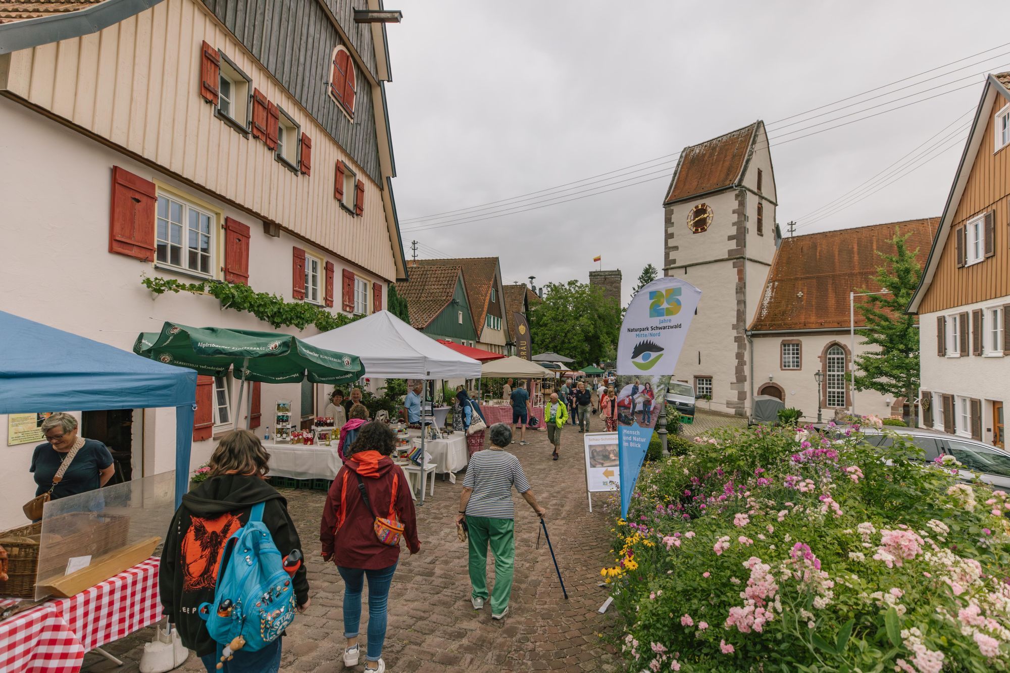 Menschen schauen sich die Produkte von Beschickern auf dem Naturpark-Markt an.