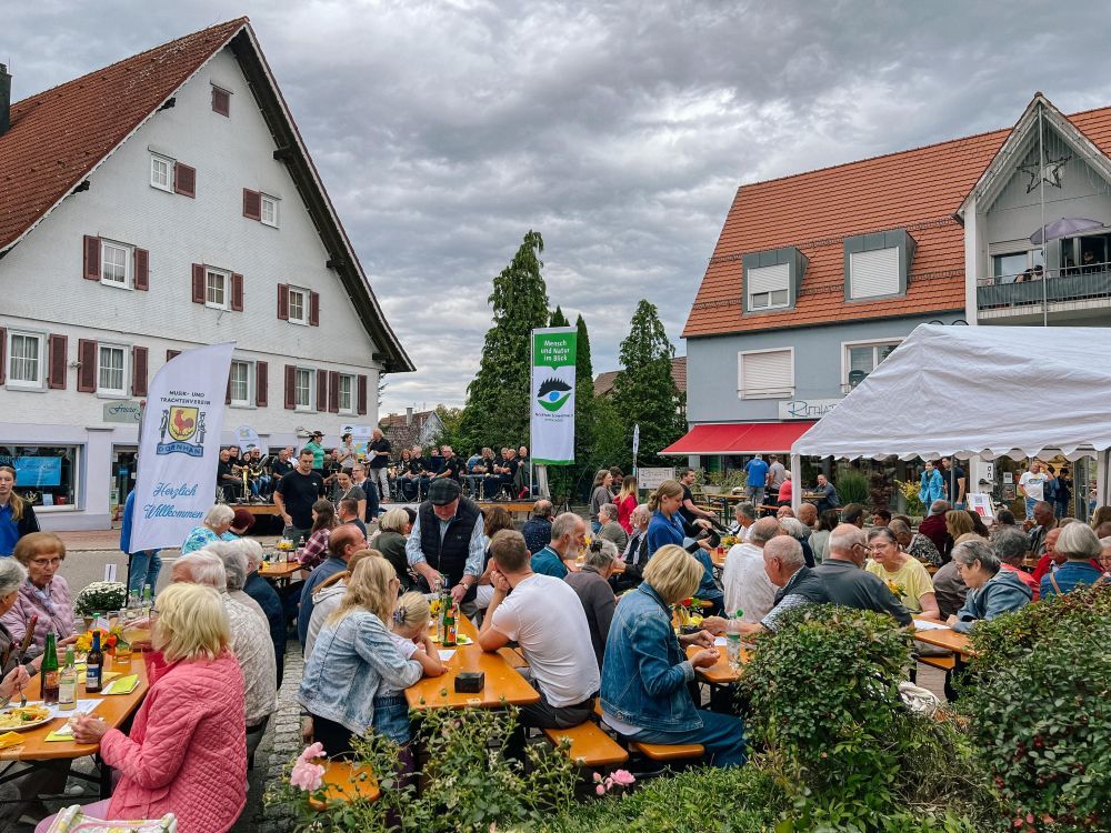 Gäste sitzen an Tischen vor der Bühne in Dornhan