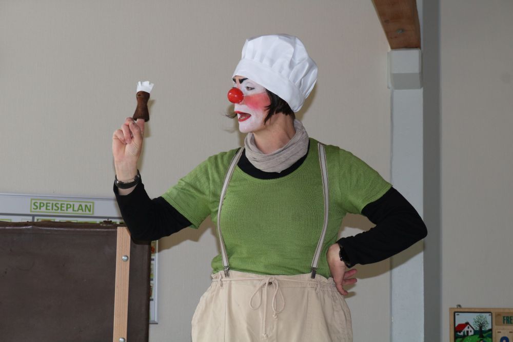 Clownin spricht mit Fingerpuppe.