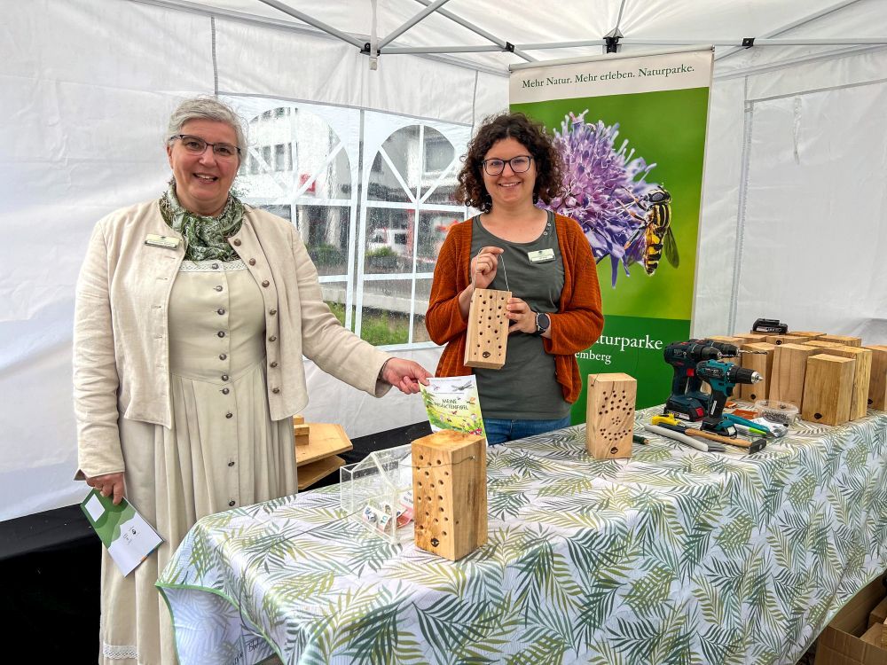 Zwei Frauen zeigen Insektenhotel aus Holz.