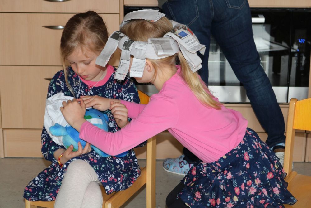 Kinder halten und streicheln die Plüscherde.