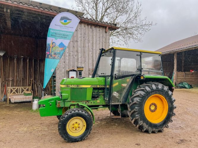 Traktor mit einer Naturpark-Fahne