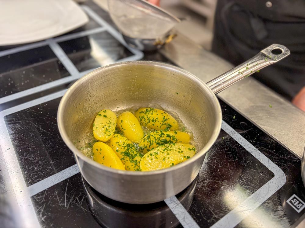 Kartoffeln im Topf mit Butter und gehackter Petersilie